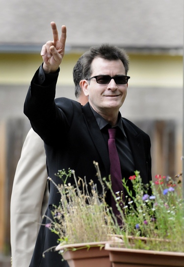 El actor Charlie Sheen saluda a la prensa