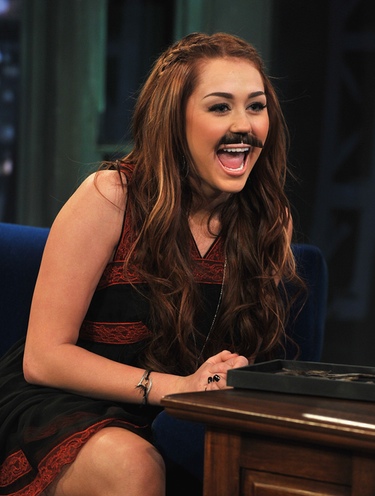 Miley Cyrus olvida los problemas familiares ocultándose tras un bigote postizo