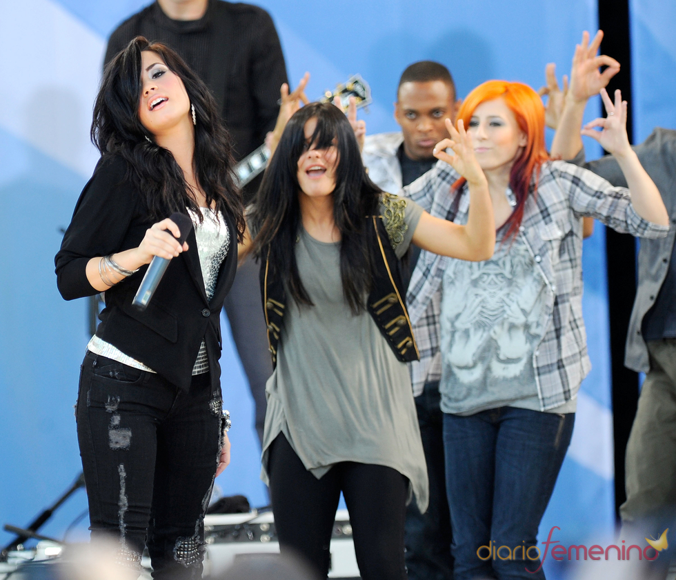 Demi Lovato y Alex Welch (pelirroja) durante una actuación