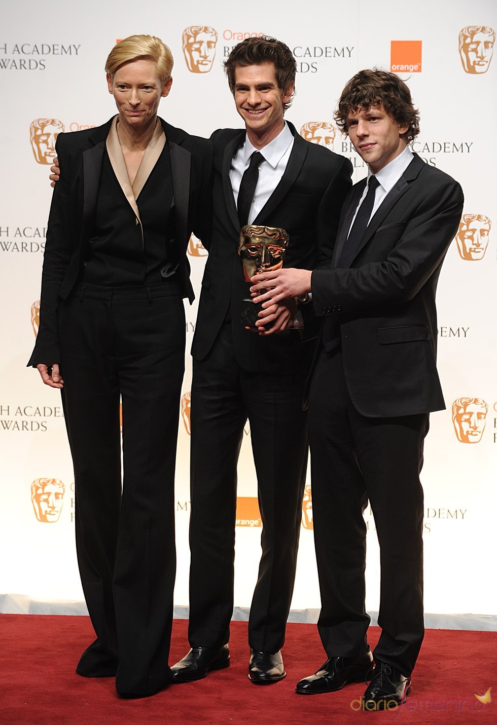 Tilda Swinton, Andrew Garfield y Jesse Eisenberg con el premio de David Fincher al mejor director. Bafta 2011
