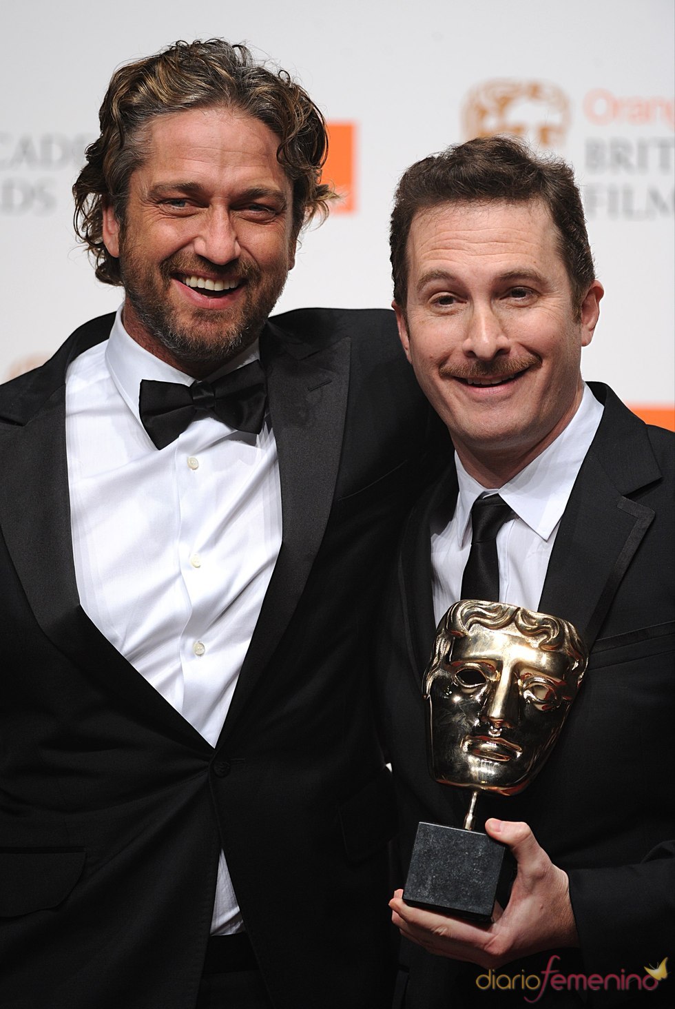 Gerard Butler y Darren Aronofsky en los Bafta 2011 con el premio de Natalie Portman