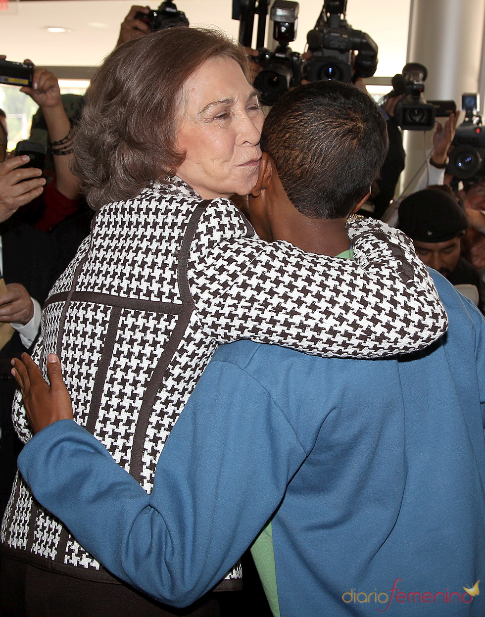 La Reina Sofía besa a un joven durante su visita a Quito