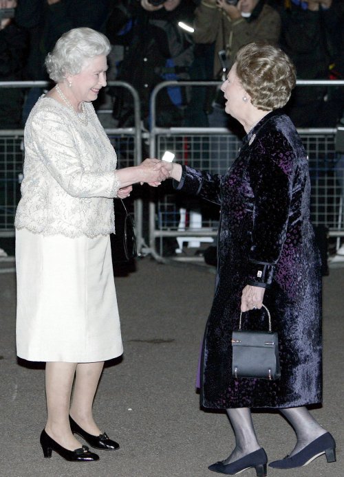 Margaret Thatcher hace una reverencia a la Reina Isabel II