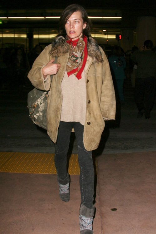 Milla Jovovich con mala cara y al natural al llegar al aeropuerto