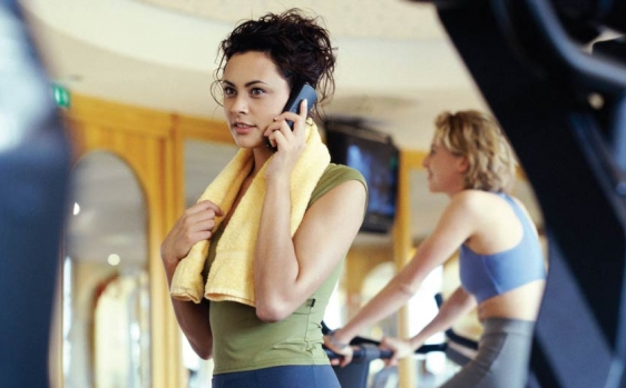 Mujer con el móvil en el gimnasio Mujer con el móvil en el gimnasio